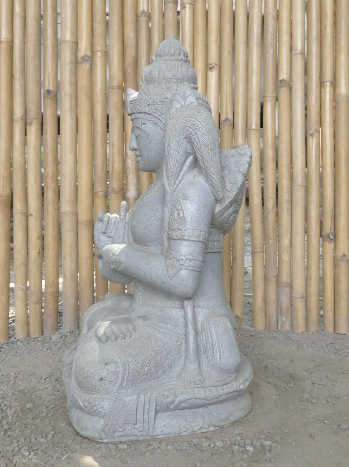  Product image 6 of the product “Seated Dewi Sri, position chakra turning the wheel, 73cm high riverstone grey, model with sativa. There is a stone eye on the left temple. ”